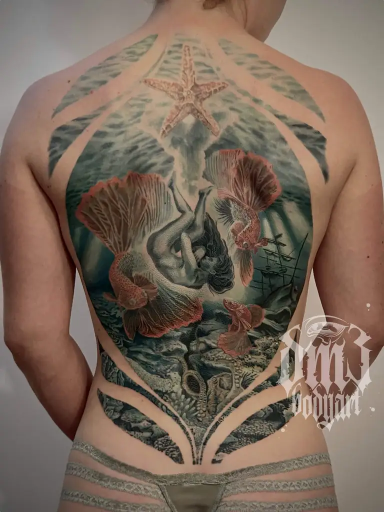 Detailreiches Realistic-Color-Tattoo: Unterwassermotiv mit Fischen, Seestern, Oktopus, Schiffswrack und Taucherin auf dem Rücken mit individuellen, kunstvollem Fluss auf dem Körper und starken Kontrasten. Dieses Farb-Tattoo wurde in einem professionellen Tattoo-Studio in Würzburg gestochen und zeigt mein Können im Bereich Realistic/Realistic-Color/Illustratives Design. Ich lege großen Wert auf hochwertige Farben, sterile Arbeitsweise und eine sichere Heilung, damit jedes Tattoo einzigartig und langlebig bleibt.