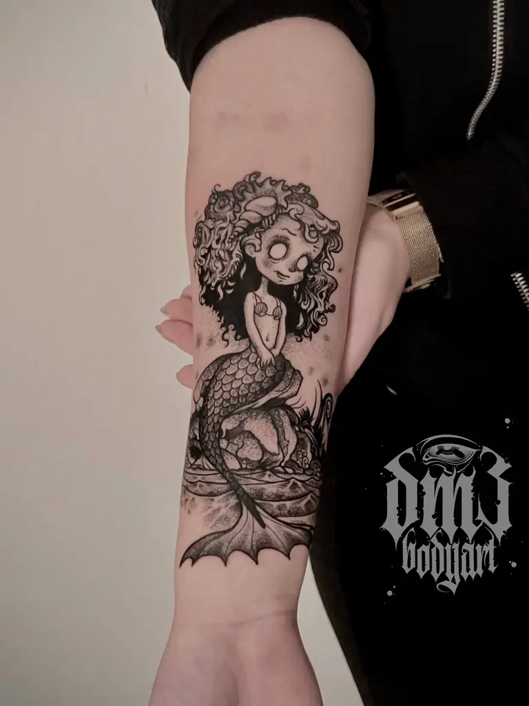 Detailreiches Blackwork Tattoo von Arielle der Meerjungfrau im Tim Burton Style auf dem Unterarm, gestochen im DM3 Bodyart Studio in Würzburg. Feine Linien, präzise Schattierungen und individueller illustrativer Stil im Dark-Art Look. Custom Tattoo mit einzigartigem Design für Tattoo-Liebhaber, die hochwertige Körperkunst suchen. Professionelles Tattoo-Studio in Würzburg – spezialisiert auf Blackwork, Dark-Art und illustrative Tattoos.