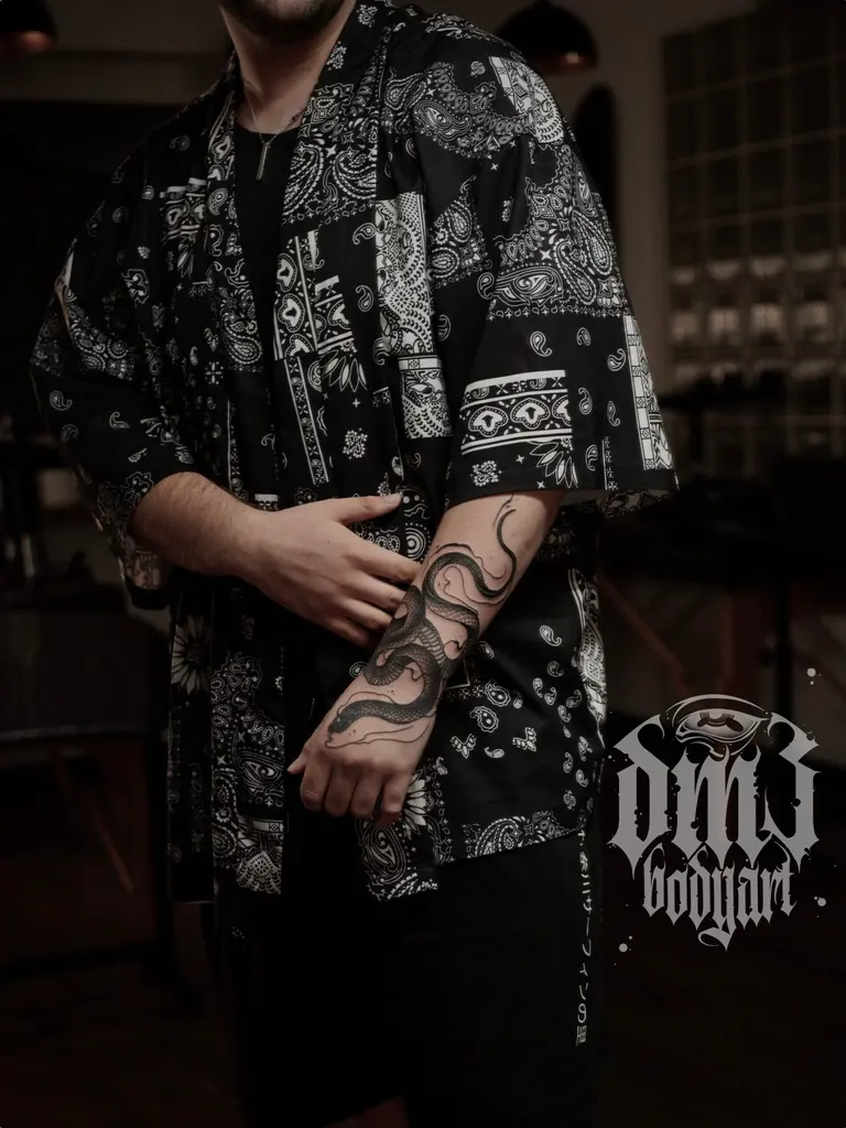 Kunstvolles Blackwork Tattoo einer sich windenden Schlange auf dem Unterarm, gestochen im DM3 Bodyart Studio in Würzburg. Narben-Cover-Ups, Farb-Tattoos und individueller illustrativer Stil im Dark-Art Look. Custom Tattoo mit einzigartigem Design für Tattoo-Liebhaber, die hochwertige Körperkunst suchen. Professionelles Tattoo-Studio in Würzburg – spezialisiert auf Blackwork, Dark-Art und illustrative Tattoos.