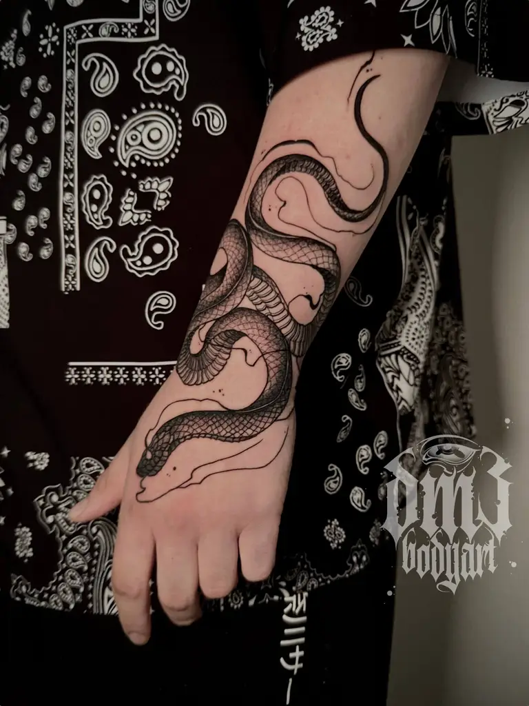 Kunstvolles Blackwork Tattoo einer sich windenden Schlange auf dem Unterarm, gestochen im DM3 Bodyart Studio in Würzburg. Narben-Cover-Ups, Farb-Tattoos und individueller illustrativer Stil im Dark-Art Look. Custom Tattoo mit einzigartigem Design für Tattoo-Liebhaber, die hochwertige Körperkunst suchen. Professionelles Tattoo-Studio in Würzburg – spezialisiert auf Blackwork, Dark-Art und illustrative Tattoos.