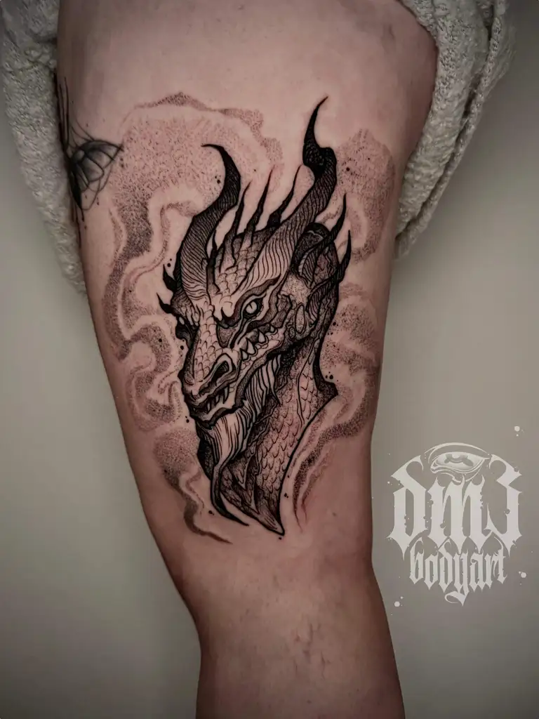 Kunstvolles Blackwork Tattoo mit vielen Details eines Drachen mit düsteren Wirkung und Rauchschwaden auf dem Oberschenkel, gestochen im DM3 Bodyart Studio in Würzburg. Dicke Linien, dunkle Schattierungen und individueller illustrativer Stil im Dark-Art Look. Custom Tattoo mit einzigartigem Design für Tattoo-Liebhaber, die hochwertige Körperkunst suchen. Professionelles Tattoo-Studio in Würzburg – spezialisiert auf Blackwork, Dark-Art und illustrative Tattoos.