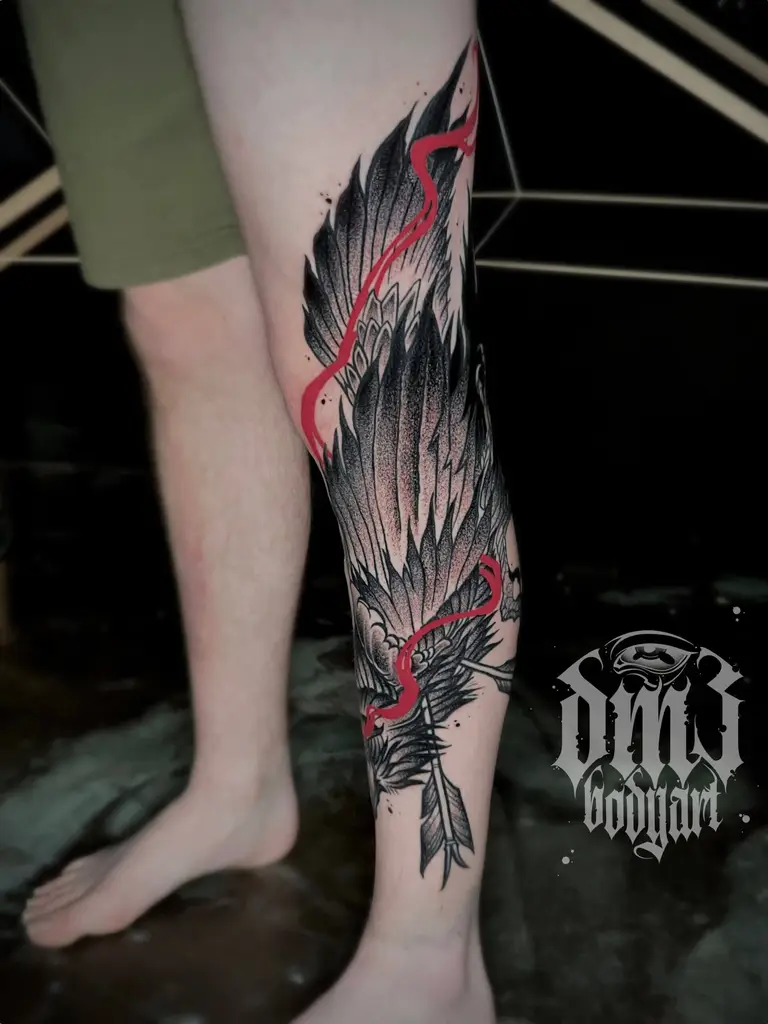 Kunstvolles Blackwork Tattoo mit rotem Farbschweif eines Rabens durchbohrt von Pfeilen auf dem Bein, gestochen im DM3 Bodyart Studio in Würzburg. Dicke Linien, dunkle Schattierungen und individueller illustrativer Stil im Dark-Art Look. Custom Tattoo mit einzigartigem Design für Tattoo-Liebhaber, die hochwertige Körperkunst suchen. Professionelles Tattoo-Studio in Würzburg – spezialisiert auf Blackwork, Dark-Art und illustrative Tattoos.