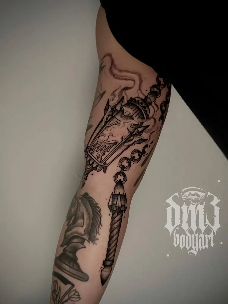 Kleines illustrative Black and Grey Tattoo einer Morgenstern-Laterne am Oberarm, gestochen im DM3 Bodyart Studio in Würzburg. Feine Linien, präzise Schattierungen und individueller illustrativer Stil im Dark-Art Look. Custom Tattoo mit einzigartigem Design für Tattoo-Liebhaber, die hochwertige Körperkunst suchen. Professionelles Tattoo-Studio in Würzburg – spezialisiert auf Blackwork, Dark-Art und illustrative Tattoos.