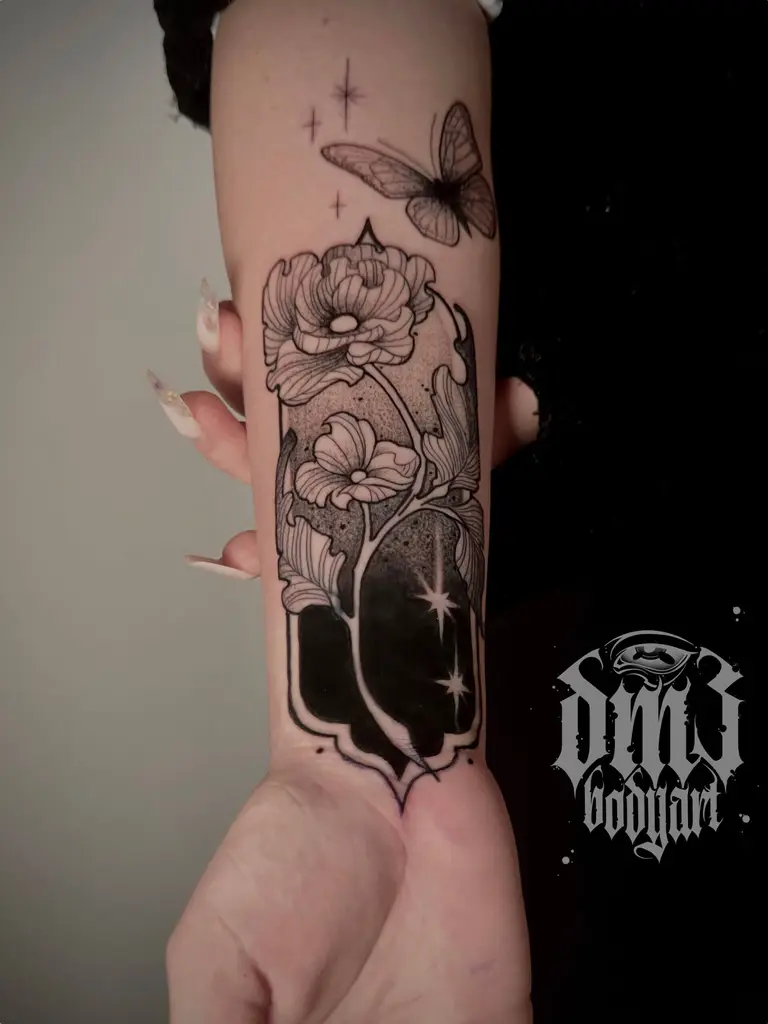 Verspieltes Illustrative Black and Grey Tattoo von kunstvollen Blumen mit Schmetterling und Sternen auf dem Unterarm als Cover-Up-Tattoo, gestochen im DM3 Bodyart Studio in Würzburg. Feine Linien, präzise Schattierungen und individueller illustrativer Stil im Dark-Art Look. Custom Tattoo mit einzigartigem Design für Tattoo-Liebhaber, die hochwertige Körperkunst suchen. Professionelles Tattoo-Studio in Würzburg – spezialisiert auf Blackwork, Dark-Art und illustrative Tattoos.