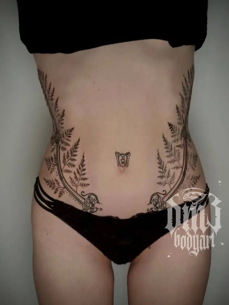 Detailreiches Black and Grey Tattoo eines kunstvollen Farns mit keltischen Knoten am Bauch, gestochen im DM3 Bodyart Studio in Würzburg. Feine Linien, präzise Schattierungen und individueller illustrativer Stil im Dark-Art Look. Custom Tattoo mit einzigartigem Design für Tattoo-Liebhaber, die hochwertige Körperkunst suchen. Professionelles Tattoo-Studio in Würzburg – spezialisiert auf Blackwork, Dark-Art und illustrative Tattoos.